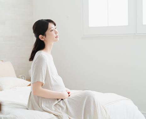 ベッドに座っている妊娠中の女性