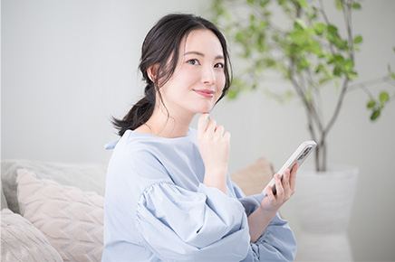 スマートフォンでビタミンCについて調べている女性