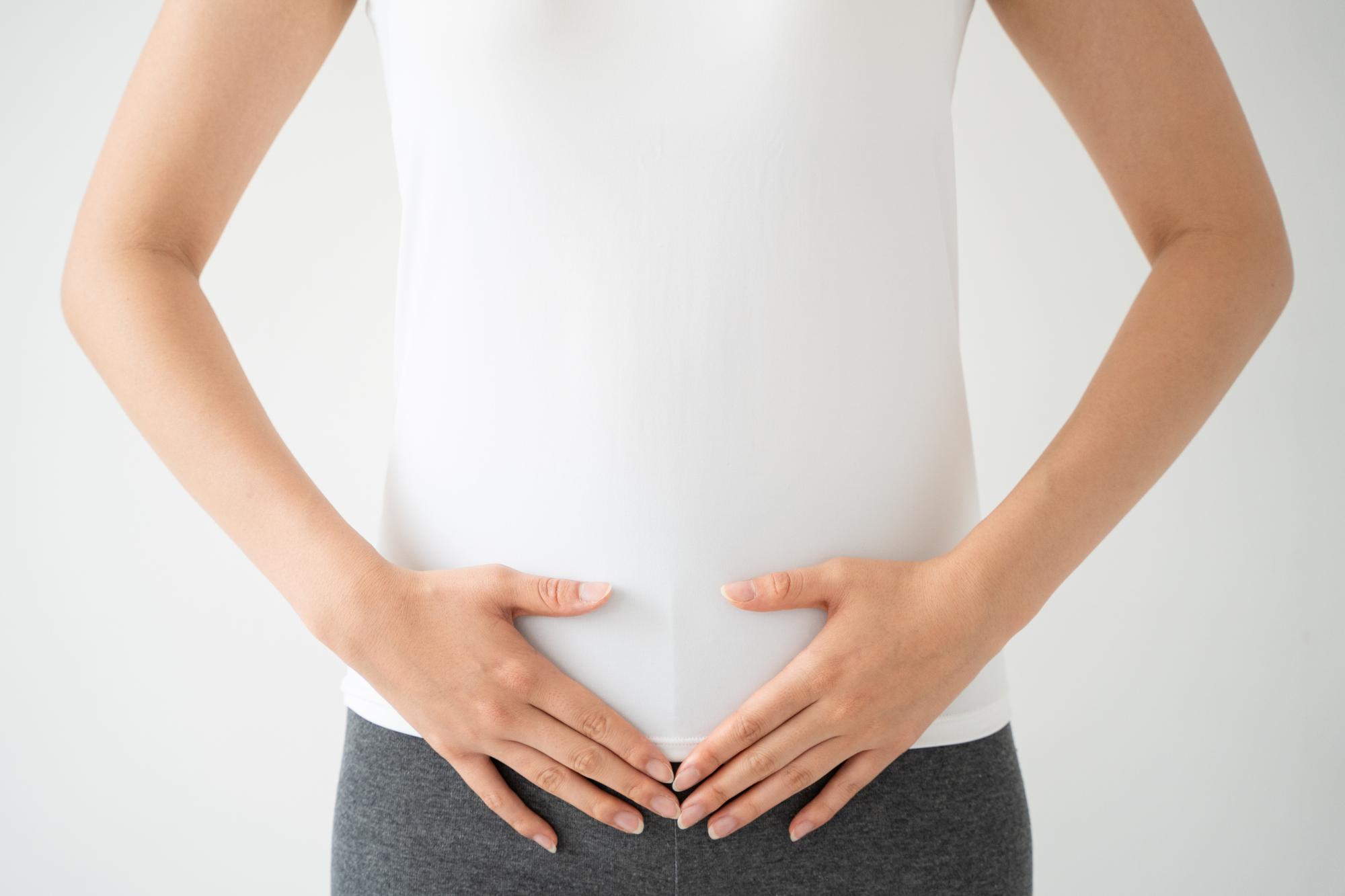 両手を子宮の前に当てている女性