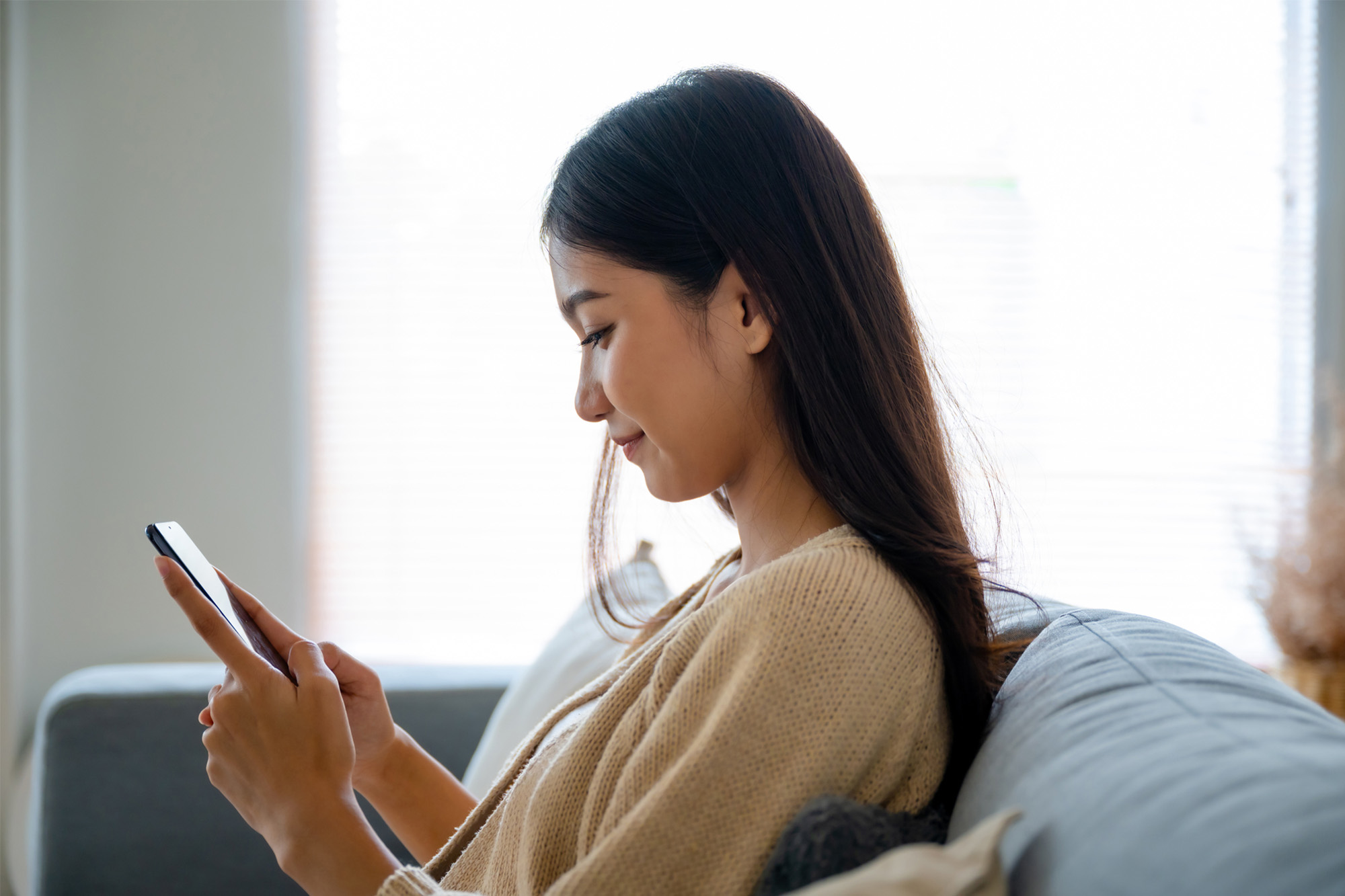 スマートフォンでアフターピルについて調べる女性