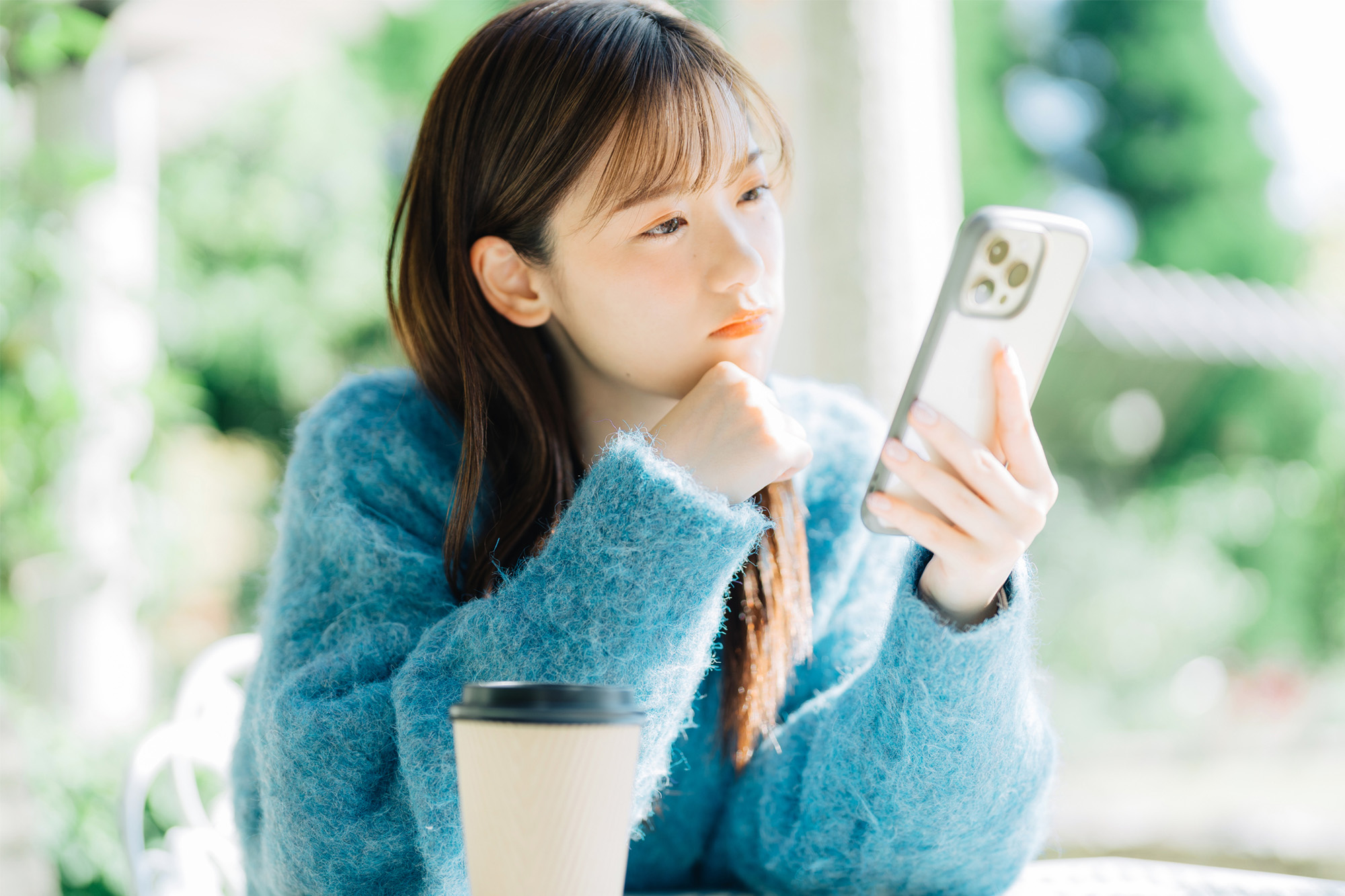 スマートフォンで緊急避妊薬について調べている女性
