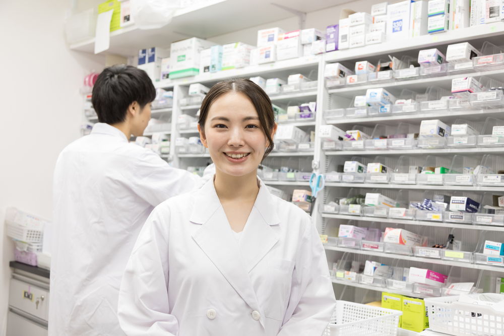 薬の前に立っている女性の薬剤師