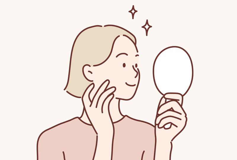 鏡を見ながら頬に手を当てて肌の状態を確認する女性のイラスト