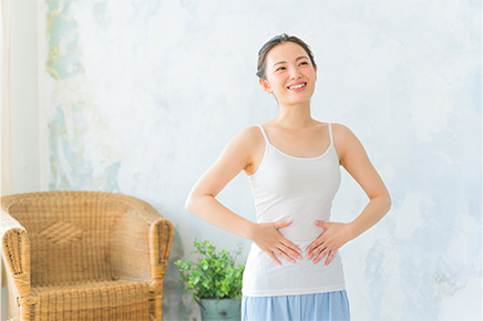 便秘でお腹に手を当てている女性