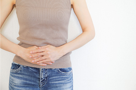 便秘でお腹に手を当てる女性