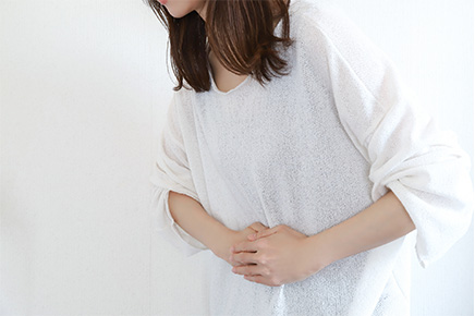 便秘による不調でお腹を抑える女性