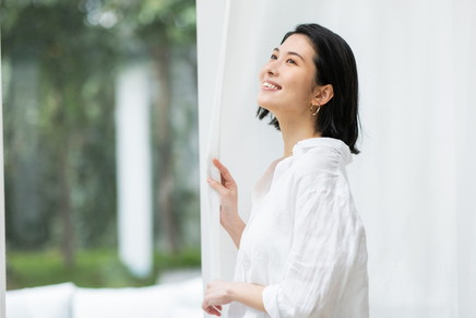 笑顔で窓の外を見ている女性