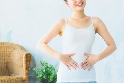お腹に手をかるくあてている女性