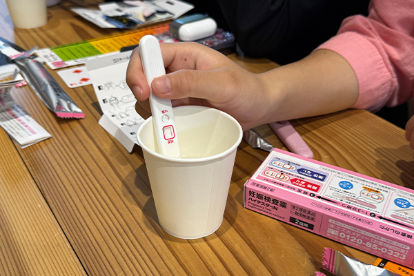教材のハイテスターN（妊娠検査薬）で水を用いて終了線の確認をする生徒たち