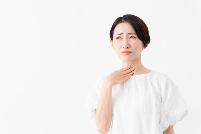 喉が痛くて悩んでいる女性