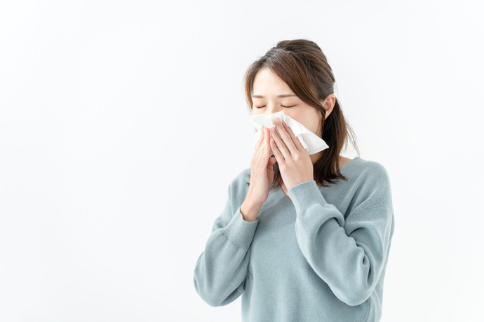 風邪で鼻をかんでいる女性