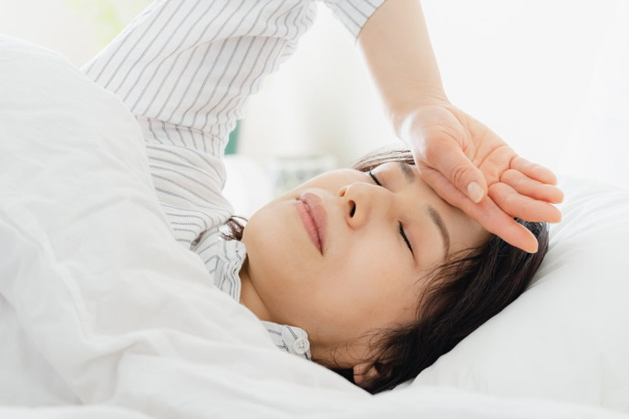 熱でベッドで横になっている女性