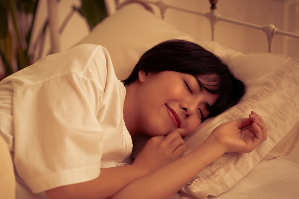 電気を消して寝ている女性