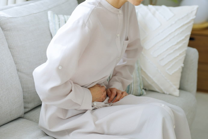 お腹をおさえている女性
