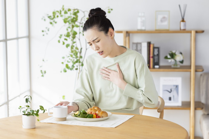 食事を食べづらそうにしている女性