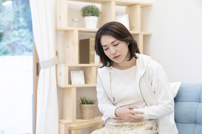 胃をおさえている女性