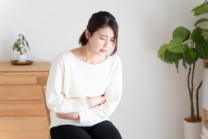 胃をおさえている女性
