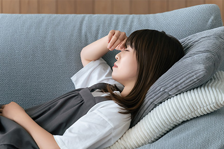 疲れてソファに寝ている女性